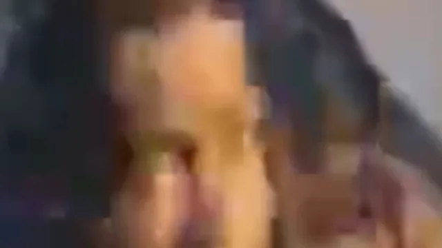 Fix pixelated video example, before: a man lying on a blue sleeping bag in a dark shot: the face, zoomed in