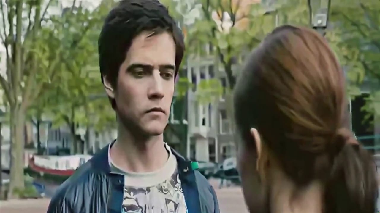 Fix pixelated video example, after: the same street scene after restoration: sharp face, hair, jacket print and building windows